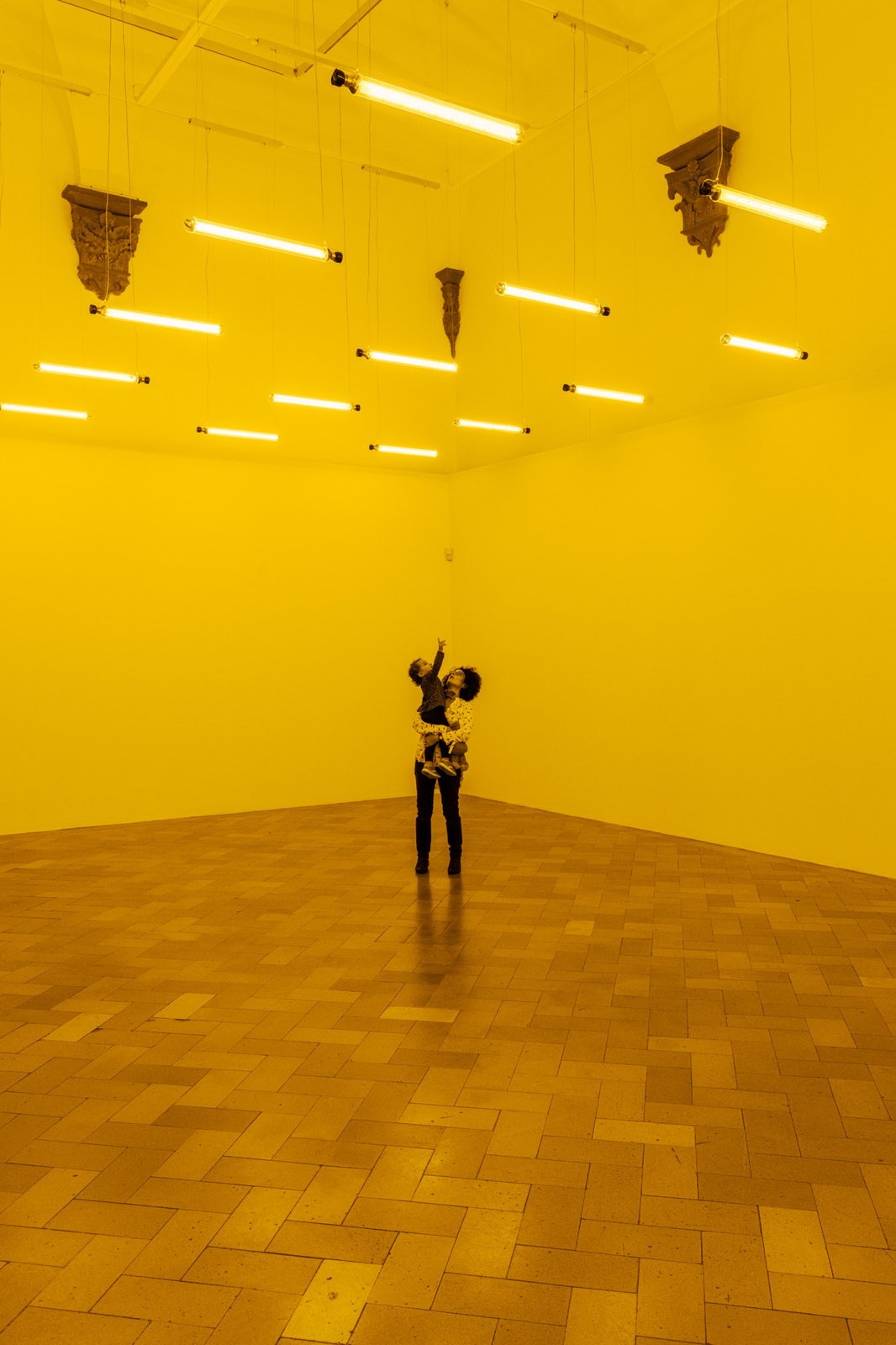 Monofrequency lights mounted to the ceiling of a white room emit a narrow range of yellow light, reducing visitors’ color perception to shades of yellow and black. The longer the visitors stay in the space, the more they begin to perceive subtle color distinctions and to correct for the yellowish lighting. Upon leaving,they momentarily perceive a bluish afterimage.